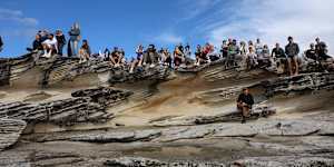 Crowds look out to the wild ocean from Trenerry Reserve.
