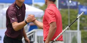 Adam Scott (right) and Adrian Meronk of Poland shake hands after finishing day one.