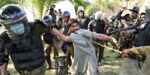 A Khan supporter is detained by police in Lahore in May.