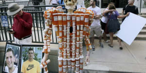 A skeleton made of pill bottles stands with protesters in August 2019 outside a court in Boston where a judge was hearing arguments against opioid maker Purdue Pharma.