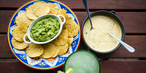 Con queso and guacamole dips with corn chips.