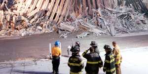 New York City firefighters look at the destroyed facade of the World Trade Centre on September 13,2001.