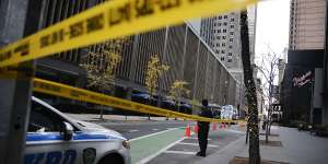 A New York police officer stands on 54th Street outside the Hilton Hotel in midtown Manhattan where Brian Thompson,the CEO of UnitedHealthcare,was fatally shot.