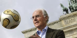 The President of the 2006 World Cup Organizing Committee,Franz Beckenbauer,presents the golden soccer ball for the 2006 World Cup final in front of the Brandenburg Gate,2006.