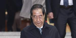 Impeached South Korean acting President Han Duck-soo leaves the government complex building in Seoul.