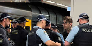 Police question a man at North Sydney station on Friday afternoon.