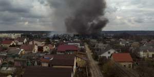 A factory and a store burn after being bombarded in Irpin on Sunday.