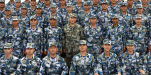 Xi Jinping (centre,in green military uniform) with members of the People’s Liberation Army (PLA) on a naval ship in the South China Sea in 2018.
