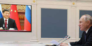 Russian President Vladimir Putin speaks with Chinese President Xi Jinping,seen onscreen,via video conference in December.