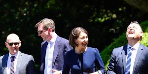 Former premier Gladys Berejiklian at Government House in 2017,with her cabinet colleagues,including then treasurer Dominic Perrottet (second from left) and the shoes that Michael Egan said weren’t “up to scratch”.