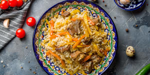 Uzbekistan's national dish and daily ritual,a hefty rice pilaf cooked with meat,onions,carrots,garlic,dried fruit,and a fair glug of oil.