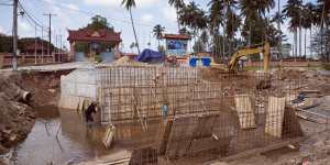 Workers labour on an under construction road outside Ream Naval Base in Sihanoukville,Cambodia.