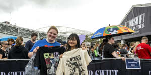 Taylor Swift fans Zoe Vacchini and Irene Lin with merchandise outside Accor Stadium on Thursday.