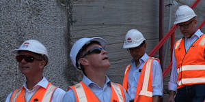 Premier Chris Minns,centre,is frustrated at the amount of community consultation needed on public infrastructure 