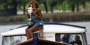 Serena Williams holds her Australian Open trophy on a cruise on the Yarra.