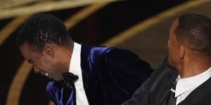 Will Smith hits Chris Rock on stage during the 2022 Oscars ceremony.