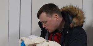 Mariana Vishegirskaya’s husband Yuri cradles his new daughter as her mother rests after a caesarian delivery. 