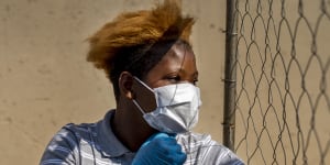 Mabatho Mphuthi is one of the very few people wearing a mask in response to the COVID-19 virus outbreak in the Diepsloot township north of Johannesburg,South Africa,on Saturday.