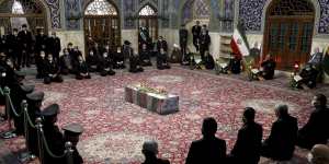 People pray over the flag draped coffin of Mohsen Fakhrizadeh.