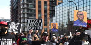 Demonstrators carry a banner during an ‘I Can’t Breathe’ Silent March For Justice in Minneapolis,Minnesota,in March 2021. Derek Chauvin knelt on George Floyd’s neck for nearly 9 minutes.