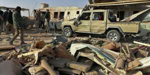 Fighters from the Kataeb Hezbollah,or Hezbollah Brigades militia,inspect the destruction at their headquarters in the aftermath of a US airstrike in Qaim,Iraq,on Monday.