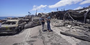 Governor of Hawaii Josh Green,left,and Maui County Mayor Richard Bissen,Jr.,speak during a tour of wildfire damage.