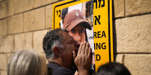 Eli Albag cries over the photograph of his daughter Liri,as he gathers with others during a protest in Tel Aviv demanding the release of dozens of Israelis who were abducted by Hamas.