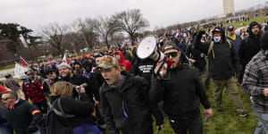 Ethan Nordean,with backward baseball hat and bullhorn,leads members of the far-right group Proud Boys in marching before the riot at the US Capitol. 
