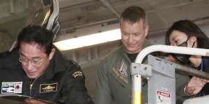 Fumio Kishida gets into the cockpit of a US fighter jet during his visit to the USS Ronald Reagan,in Sagami Bay,southwest of Tokyo on November 6,2022. 