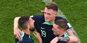 Milos Degenek,Harry Souttar and Kye Rowles embrace after Australia’s win over Tunisia.