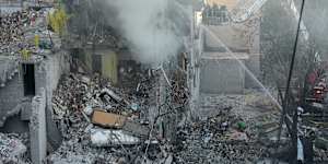 Emergency services personnel work to extinguish a fire after a Russian strike on Kyiv.