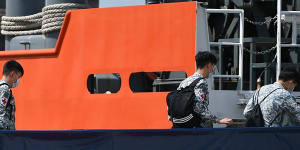 Crew board the MV Swift Rescue,a submarine support and rescue vessel,before being dispatched to Indonesia from Singapore.