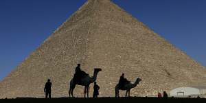 Policemen are silhouetted against the Great Pyramid in Giza.