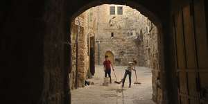 Two boys sweep in the souq,or market,of the old city in Hebron. 