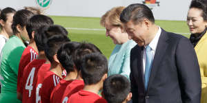 Then German chancellor Angela Merkel and Chinese President Xi Jinping greet players before a match between the U12 teams of Germany and China in Berlin,in 2017.