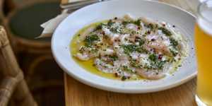 Swordfish carpaccio sprinkled with pink peppercorns and chives.