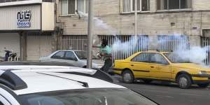 A demonstrator in Tehran throws tear gas back at Iran’s anti-riot police during a protest over the death of a young woman.