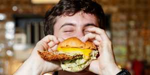 Bartender Hugh MacMaster with the fish burger at The Bat&Ball Hotel in Redfern. 