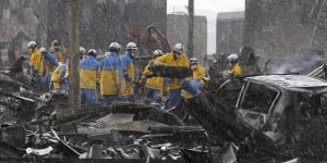 Police officers search through the debris from a fire at a market in Wajima,Ishikawa prefecture on Saturday after a series of powerful quakes set off a large fire.