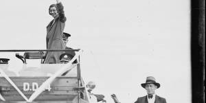 Amy Johnson waving to the crowds from the back of a car,Sydney,1930.