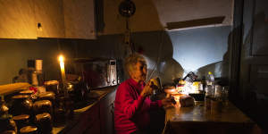 Natalie Zemko,81,drinks tea by candlelight after power was restricted in Kyiv after Russian strikes damaged electricity plants.