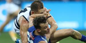 Joel Selwood throws everything at North’s Kayne Turner. 