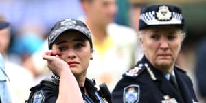 Constable Bree Trost (left) and Commissioner Katarina Carroll at the Gabba on Saturday during a moving tribute to colleagues Rachel McCrow and Matthew Arnold,and Good Samaritan neighbour Alan Dare.