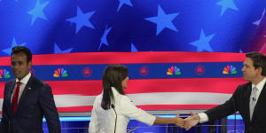 Former US ambassador to the UN Nikki Haley shakes hands with Florida Governor Ron DeSantis as businessman Vivek Ramaswamy walks past.