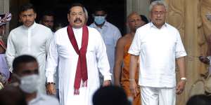 Sri Lanka’s outgoing Prime Minister Mahinda Rajapaksa,centre,leaves with his younger brother,President Gotabaya Rajapaksa,right,after being sworn in as the prime minister at Kelaniya Royal Buddhist temple in Colombo,Sri Lanka,August 9,2020. 