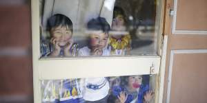 Uighur children Efruz,Abdukuddus,Elif and Melek watch as a car pulls into their driveway at their home in Adelaide.