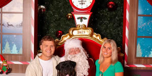 Morihovitis (right) gets her own 2023 Santa photo at Greensborough Plaza shopping centre with Santa,with her partner Ben Cerni and dog Boof.