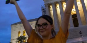 An activist marks the first anniversary of the Supreme Court’s decision that overturned Roe v Wade,by displaying a neon sign in support of abortion access in front of the US Supreme Court.