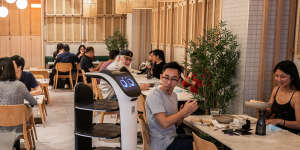 Kata Kita's cat-faced robot delivers plates to tables.