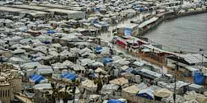 A tent camp for displaced Palestinians stretches across the Gaza City seaport.